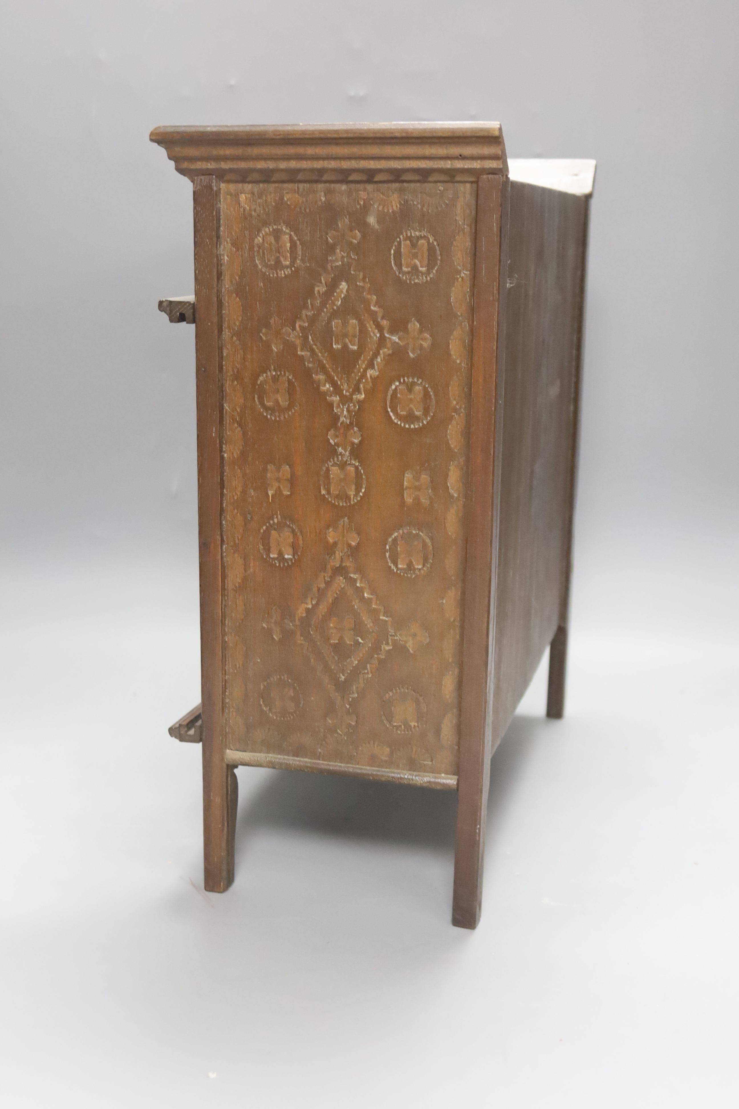 A 19th century French miniature carved oak cupboard with sliding doors. 37cm